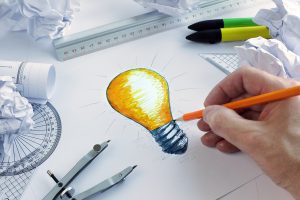 Designer drawing a light bulb, concept for brainstorming and inspiration